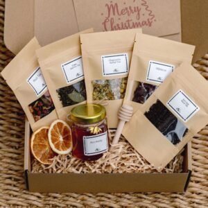 Gift box with five loose leaf teas, natural honey, dried orange, and a wooden honey dipper